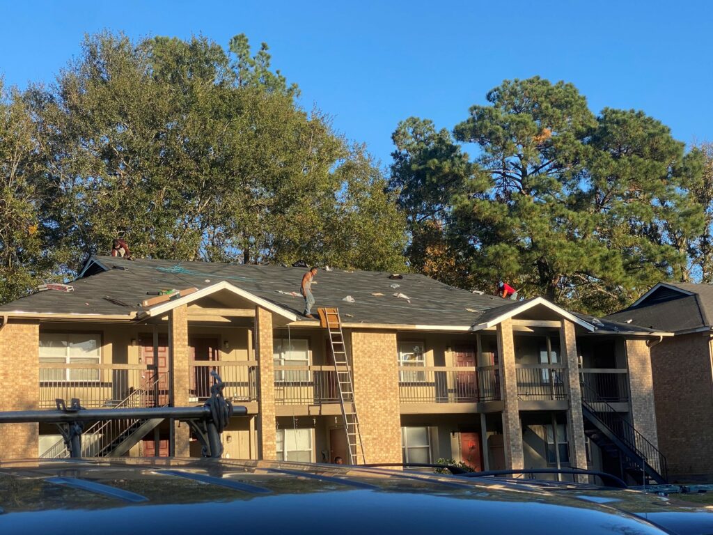 Front of unit image of Grumbles team during a reroof project on an apartment building